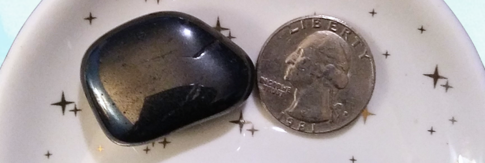 Hematite Healing Crystal, Tumbled, 1 Stone in moon-shaped dish on light background