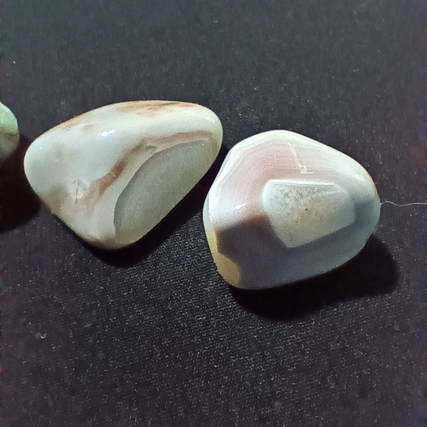 Pink Banded Agate Healing Crystal, Tumbled, 1 Stone, 2 stones on black background