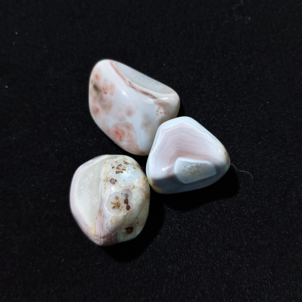 Pink Banded Agate Healing Crystal, Tumbled, 1 Stone, 3 stones on black background