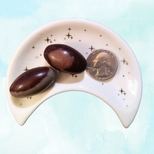 Shiva Lingam Healing Crystal, Tumbled, 1 Stone, 2 stones in moon-shaped dish on light background