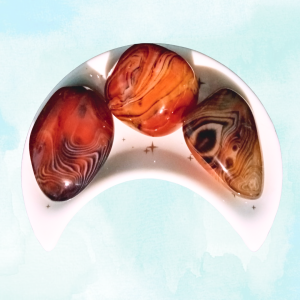 Silk Agate Healing Crystal, 3 stones in a moon-shaped dish on light background
