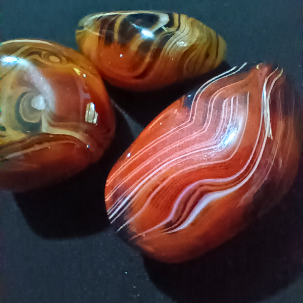Silk Agate Healing Crystal, closeup, 3 stones on black background