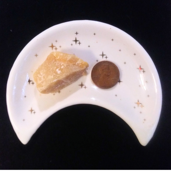 Yellow Aventurine Healing Crystal, Raw, 1 Stone in moon-shaped dish on black background