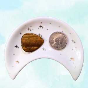 Tigers Eye Healing Crystal, Guitar Pick, 1 Pick in moon-shaped dish on black background