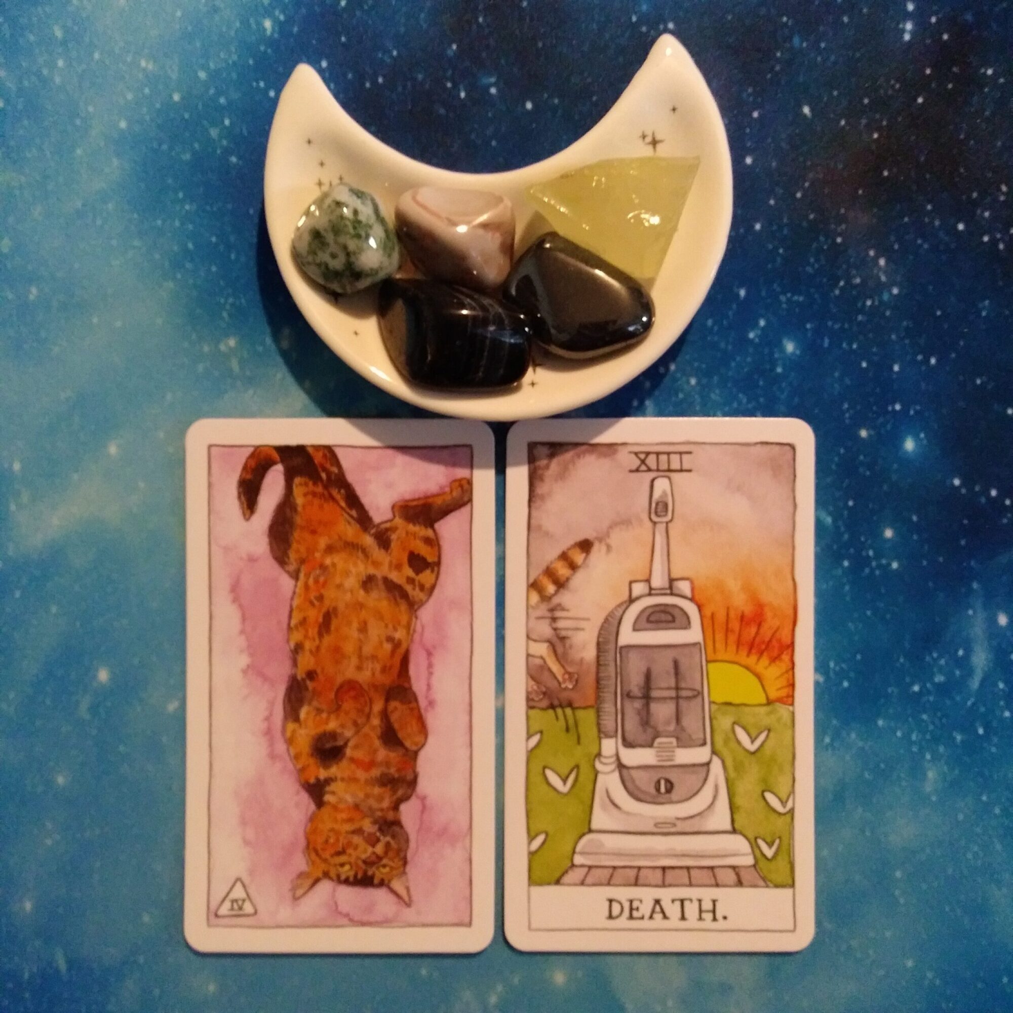 2 Cat Tarot cards and crystals on a starry blue background