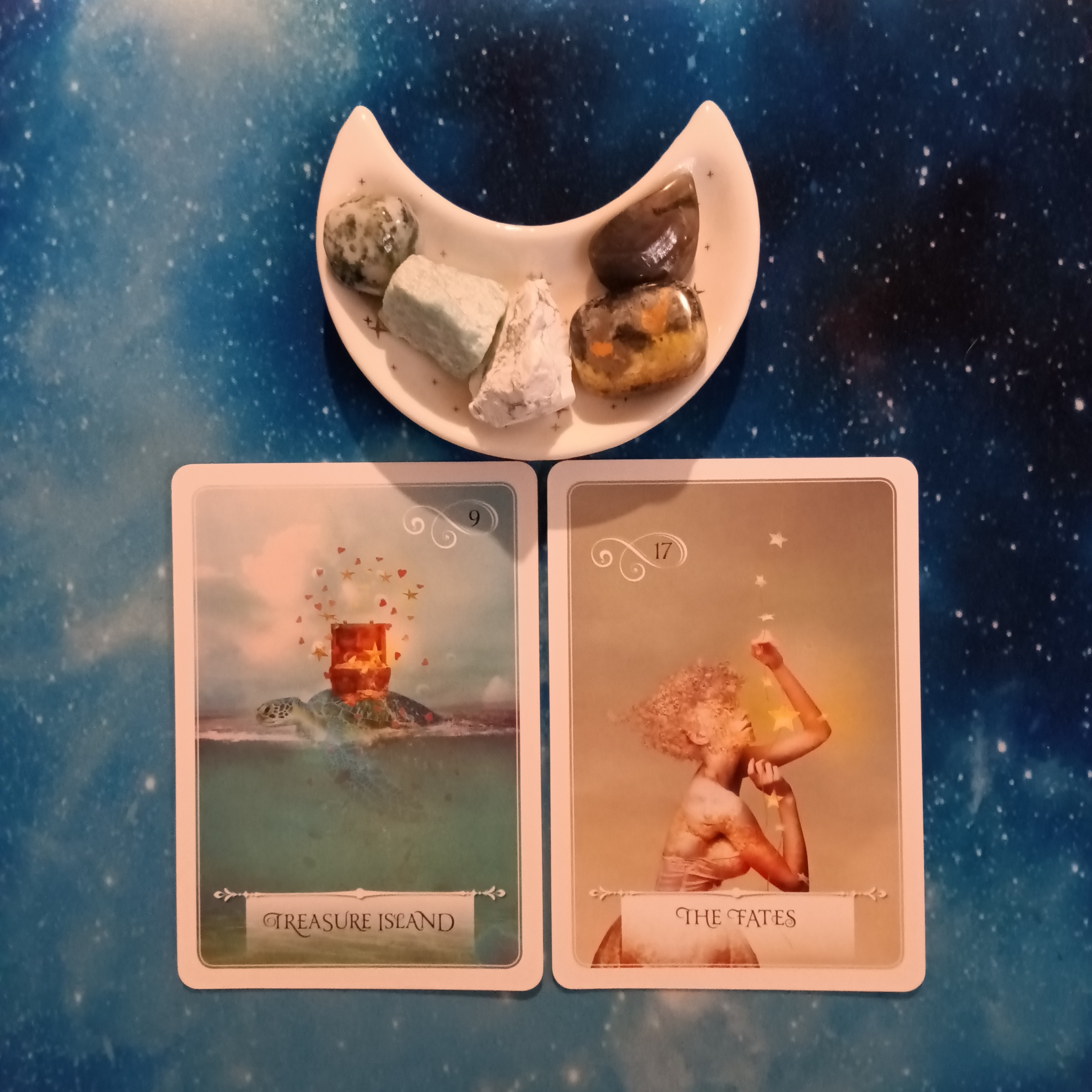 2 Wisdom of the Oracle cards and crystals on a starry blue background