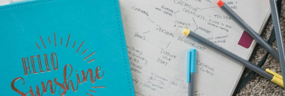 Having Trouble Creating a Journaling Habit? Try This! Blue journal with the words "Hello Sunshine" on the cover and markers