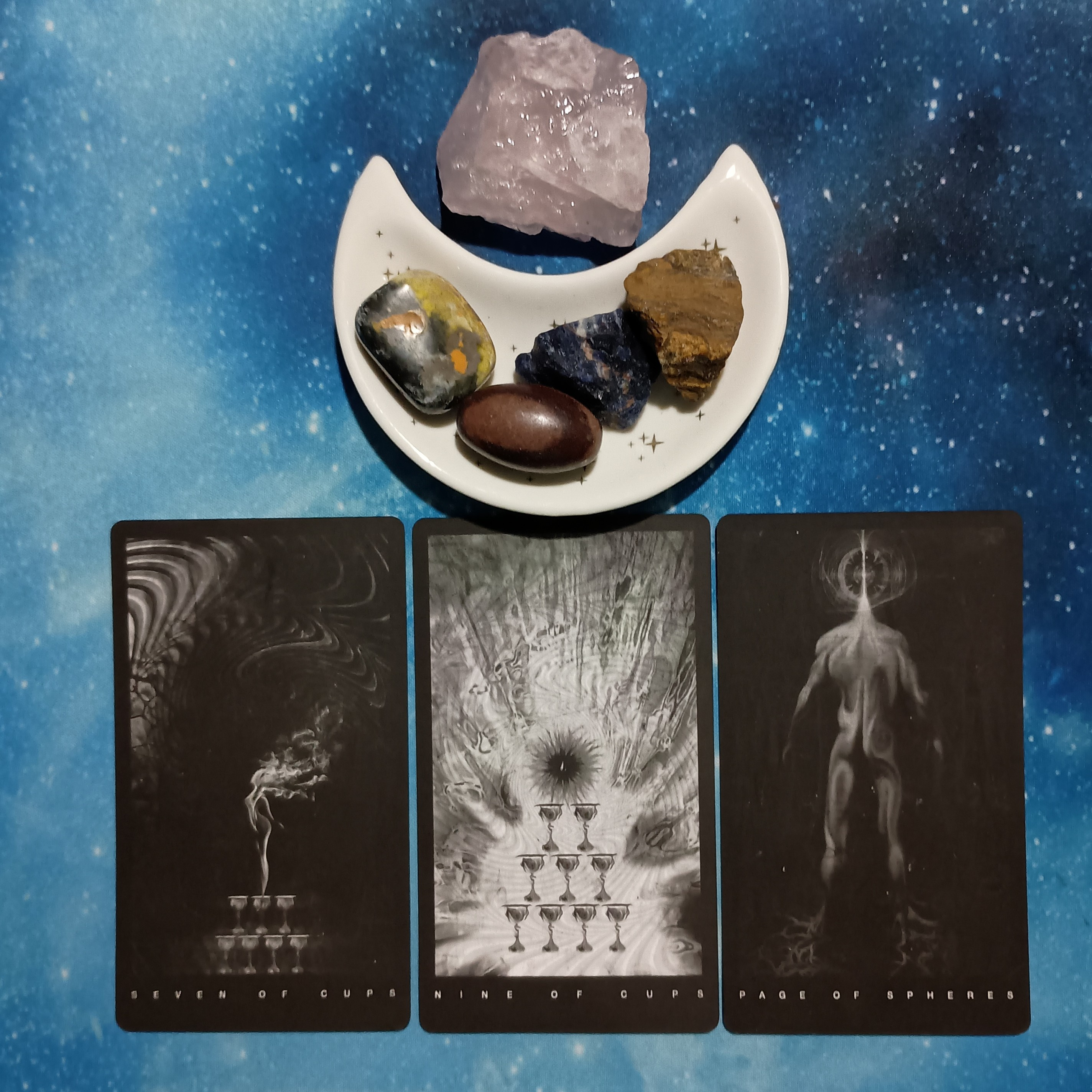 Abundance All Around You ~ A Message From the Universe, Black Tarot cards and crystals on a starry blue background