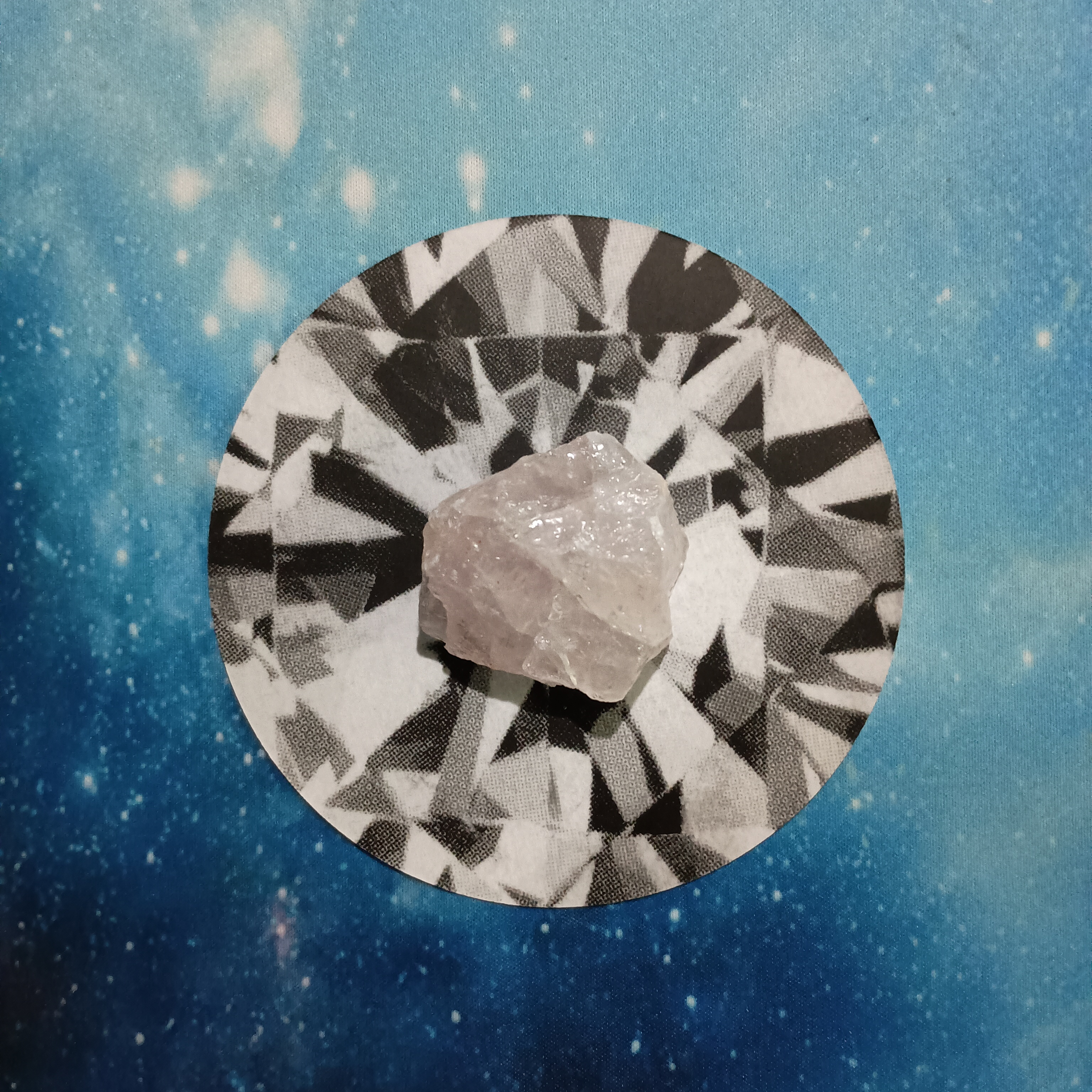 New Moon Pick-a-Card Tarot Reading for June 2025, pile 1 - rose quartz (pink) stone and an oracle card, face down, on a starry blue background