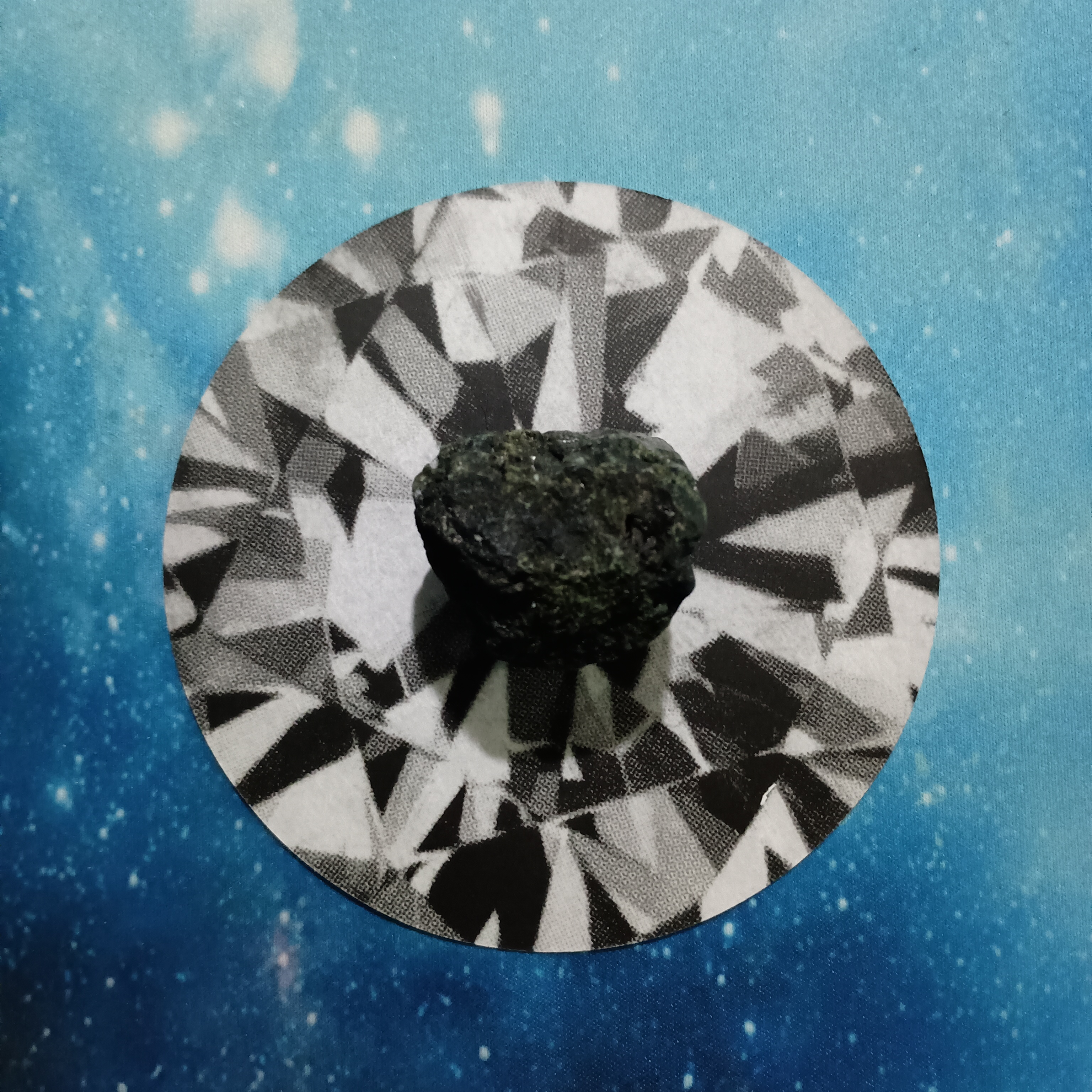 New Moon Pick-a-Card Tarot Reading for June 2025, pile 4 - Black Tourmaline stone and an oracle card, face down, on a starry blue background