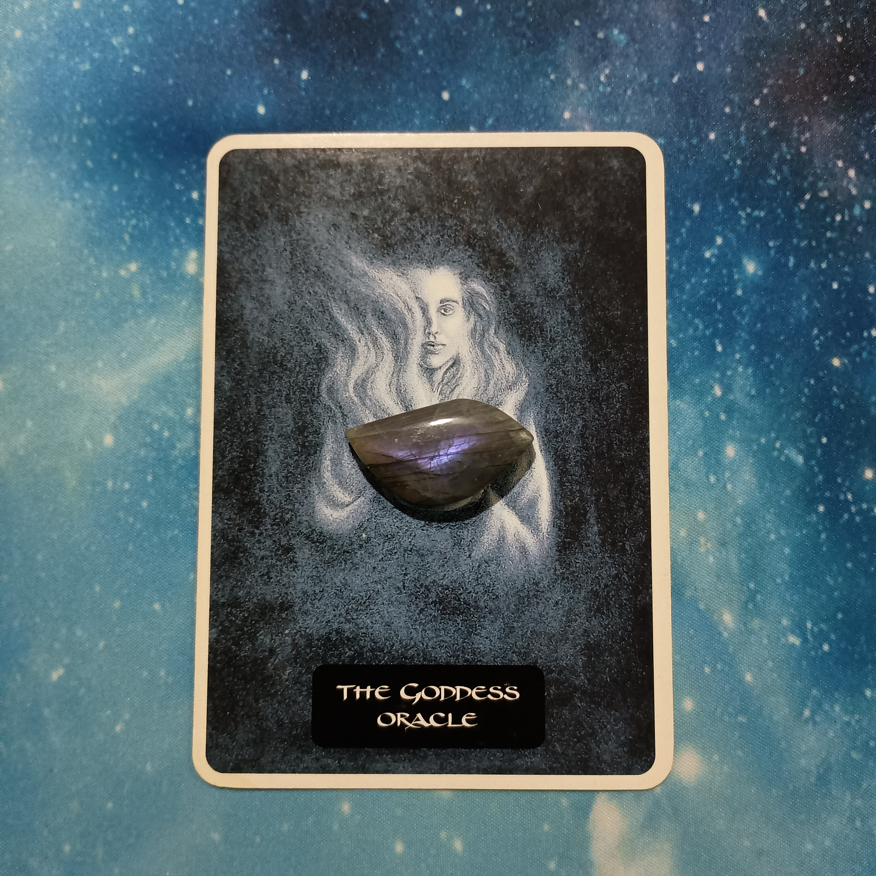 Full Moon Pick-a-Card Tarot Reading for July 2025, Pile 1, Labradorite crystal (gray with purple flash) on 1 oracle card, face down