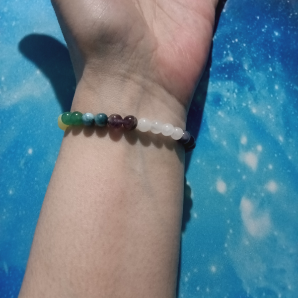 Rainbow Soul Chakra Bracelet for Balance & Alignment, wrist under view, blue background