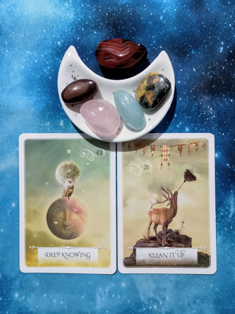 Unbury Your Peace & Power: A Message From the Universe, 2 Wisdom of the Oracle Oracle cards and crystals on a starry blue background