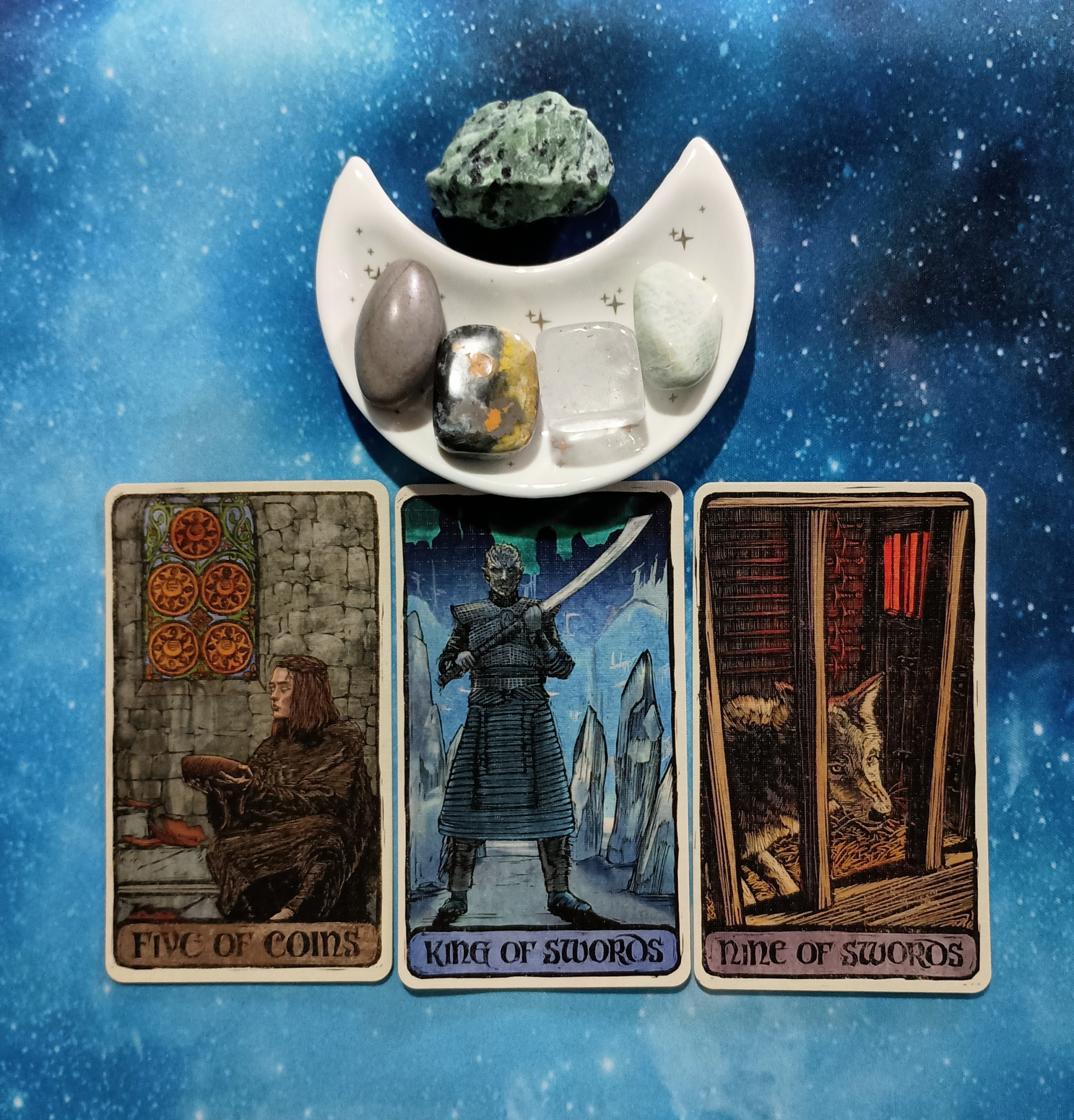 Sunny Skies Ahead! A Message From the Universe, 3 Game of Thrones Tarot cards and crystals on a starry blue background