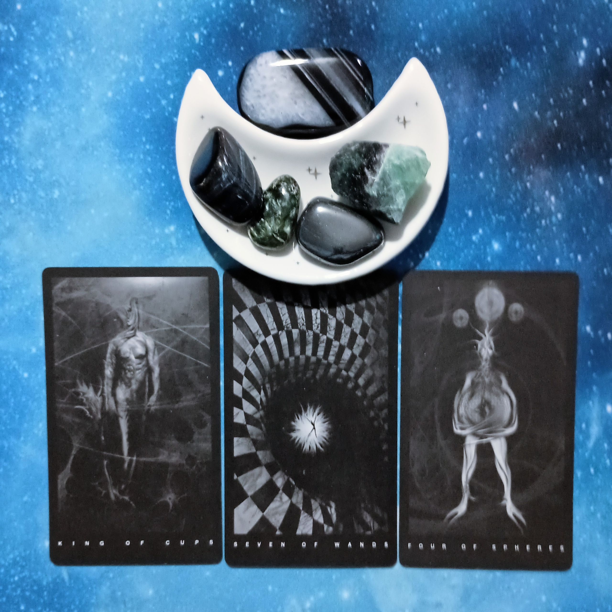 The Art of Not Losing It: A Message From the Universe, 3 Black Tarot cards and crystals on a starry blue background