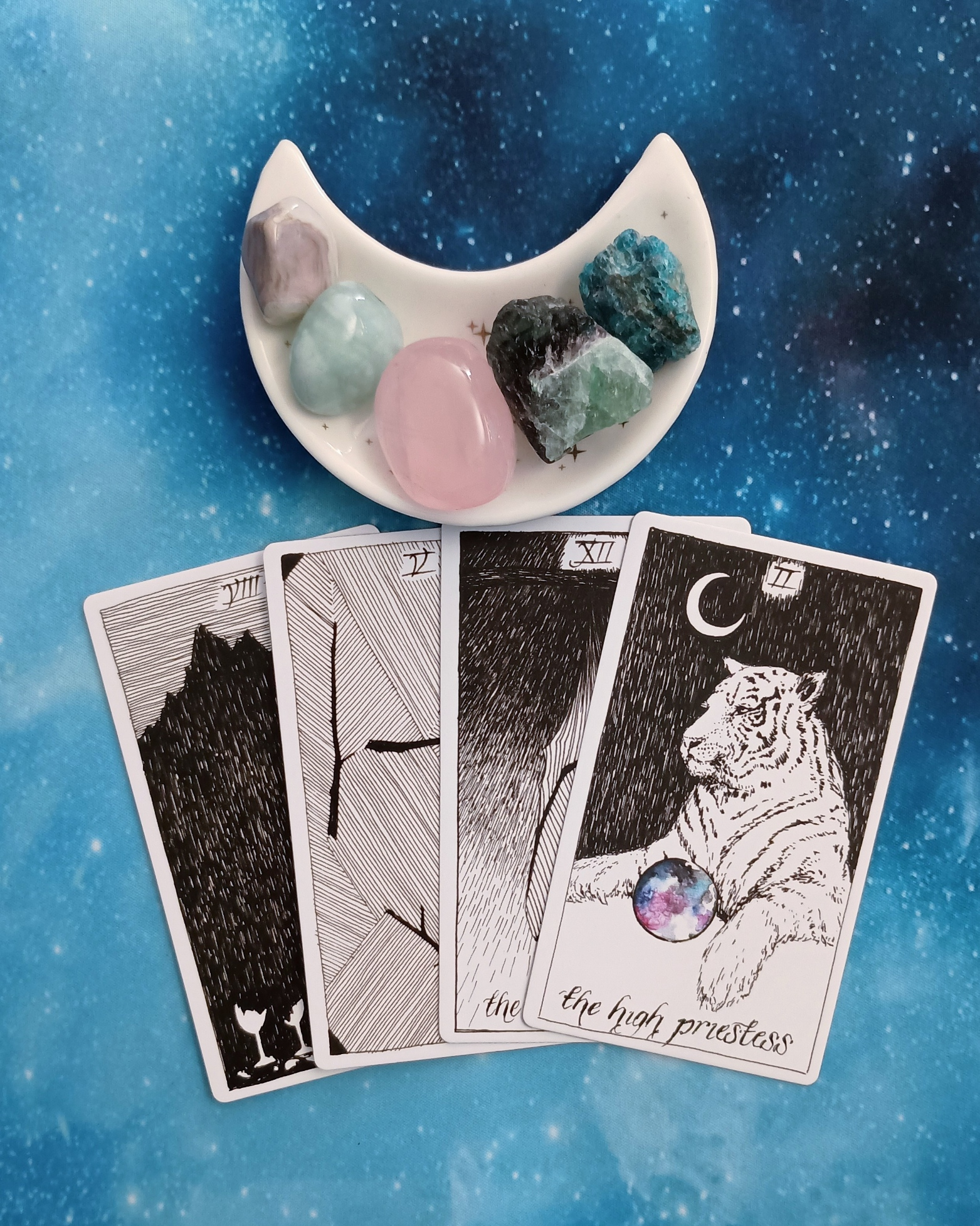 Feeling Stuck? A Message From the Universe, 4 Wild Unknown Tarot cards and crystals on a starry blue background
